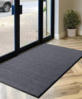 Heavy Duty Rubber Door Mat 3 By 5 Feet For Indoor Outdoor Use Waterproof And Easy Clean Entry Mat Traps Dirt And Moisture Ideal For High Traffic Patios Garages And Commercial Entrances placed in a doorway with a plant nearby.