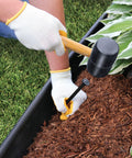 Person installing Heavy Duty 40 Foot Landscape Edging Kit With YardPack 5 Inch Flexible Lawn Border using mallet and spike