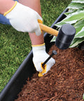 Installing Pro Grade Landscape Edging Kit 5 Inch By 20 Foot Heavy Duty Garden Border with spike and mallet in garden bed