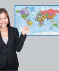 Woman pointing at world map from Three Pack World Map Poster Set And USA Map Poster With Periodic Table Chart For Kids, Laminated And Tear Resistant