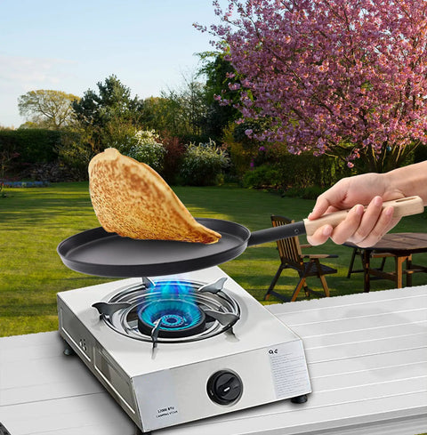 Preseasoned 8 Inch Frying Pan Skillet With Detachable Wooden Handle in outdoor setting, frying a crepe on a gas stove