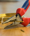 6 Inch Needle Nose And Combination Pliers With Slim Head And Anti Twist Jaws gripping wire on a wooden surface