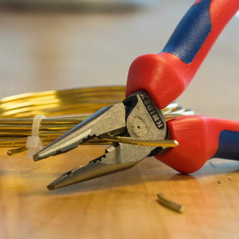 6 Inch Needle Nose And Combination Pliers With Slim Head And Anti Twist Jaws gripping wire on a wooden surface