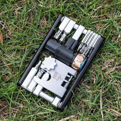 Compact Bicycle Multi Tool With CO2 Inflator And Chain Tool For Road And Mountain Bikes Torx Hex Screwdriver Set shown on grass