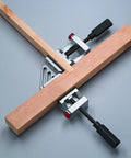 Quick-Jaw Right Angle Corner Clamp for Cabinets and Boxes in use, clamping two wooden boards at 90 degrees, showing ergonomic handles