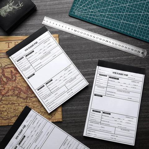 6 Pack VFR Pilot Kneeboard Notepad Pads, 50 Pages Each, Pre Printed Flight Planning Pages on desk with ruler