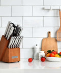 German Stainless Steel Kitchen Knife Set With Built In Sharpener in wood block on kitchen counter with cutting boards and fruits