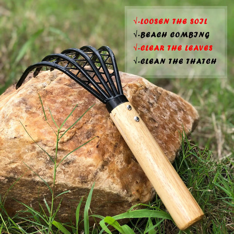 Five Claw Garden Rake Dethatching Tool For Loosening Soil Weeding Leaf Removal Beach Treasure Digging And Shell Cleanup next to a rock.