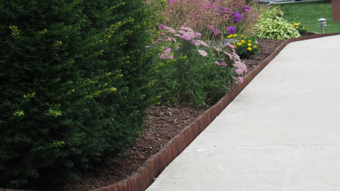 Brown Lawn And Landscape Border Edging For Garden Beds And Walkways With Flexible Design along a paved path and flower bed.