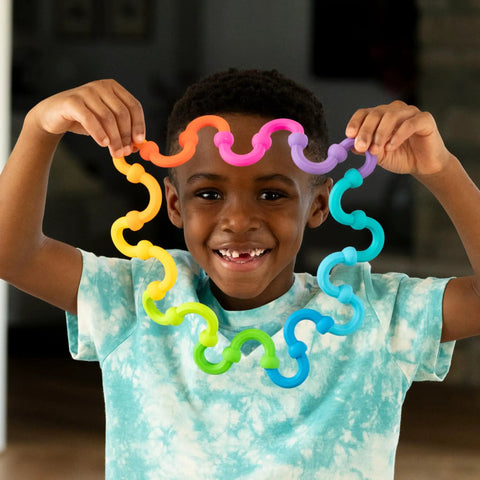 Plip Links Silicone Building Toys For Open Ended Creative Play A Fun Construction Set For Kids Aged 3 To 12 That Sparks STEM Skills Through Pattern Building And Preschooler Hands On Imagination, child holds rainbow silicone links