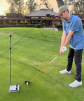 Golfer using Golf Swing Trainer Cube With 12 Adjustable Club Positions, Guided Strikes Tool, and Alignment Rods on practice green.