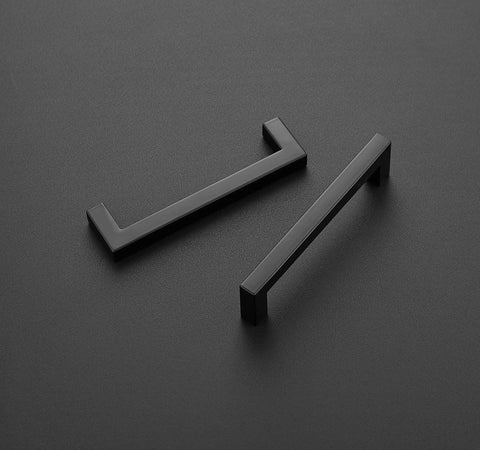 Square Bar Cabinet Handles Matte Black Set Of 10 With 5 Inch Hole Center And 5-1/2 Inch Overall Length laying on a dark surface