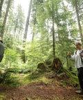Hikers with Pair Of Adjustable Trekking Poles With Aircraft Grade Aluminum, Cork Grip, And EVA Extended Grip In Bright Orange on forest trail