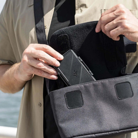Man placing Fresh Hot Pink Memory Card Wallet Slick Waterproof Storage Holder For SD And Micro SD Cards into a bag.