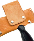Close-up of Five In One Survival Hatchet Head with leather sheath, visible rivets, and partially visible handle.