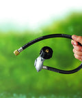 Hand holding 24-inch propane hose and regulator kit for Genesis and Summit gas grills with secure flow control and leak-free hookup.
