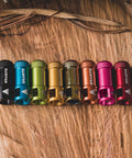 Colorful oil slick alloy valve caps with built in valve core remover, no tools needed for Presta valves, on wood surface