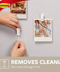 Hand hanging photo with Quartz Plastic Spring Clips 8 Pack For Dorm Décor Damage Free Hanging, easy removal shown on wall