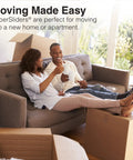 Couple sitting on sofa surrounded by moving boxes, using 20 Piece Assorted Felt Furniture Sliders Set For Hard Surfaces.