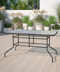 Modern Rippled Glass Outdoor Dining Table With Umbrella Hole, Rectangular 31.5 Inch By 55 Inch, Tempered Glass Top, Black Metal Frame For Patio Or Backyard Gatherings on a patio with potted plants.