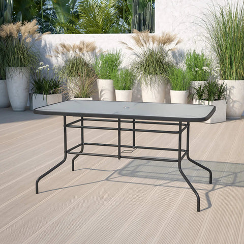 Modern Rippled Glass Outdoor Dining Table With Umbrella Hole, Rectangular 31.5 Inch By 55 Inch, Tempered Glass Top, Black Metal Frame For Patio Or Backyard Gatherings on a patio with potted plants.