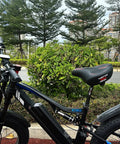 Wide Bike Seat For Men And Women Extra Large Comfort Saddle on black e-bike against greenery outdoors.