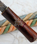 Close-up of Damascus Steel Fixed Blade Camping Knife With Walnut Wood Handle, showing brass bolster detail.
