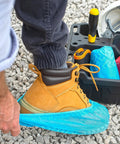 Person putting on Ultra Thick Disposable Shoe Covers 120 Pack 60 Pairs Non Slip Water Resistant Booties for Outdoor Use
