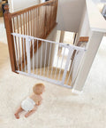 Extra Wide Baby Gate For Stairs And Doorways, Auto Close, mounted at top of staircase with baby in diaper on carpeted floor.