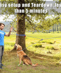 Backyard Dog Zipline Kit With 100 Ft Run Line And Trolley in use, showing dog on leash between trees in a yard.