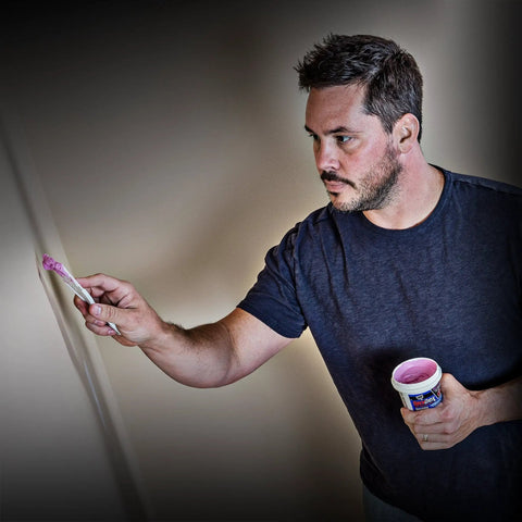Man applying Spackling For Interior And Exterior Use 1/2 Pint White No Mess Easy To Use Squeeze Tube With Dry Time Indicator on wall