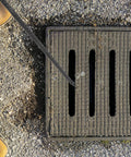 Heavy Duty Steel Manhole Cover Opener With Solid T Handle Grip Rust Resistant Multi Purpose Pull Lifter Hook For Sewer Lid Snagging And Jobsite Hauls No Sweat Tradesman Gear near a sewer grate.