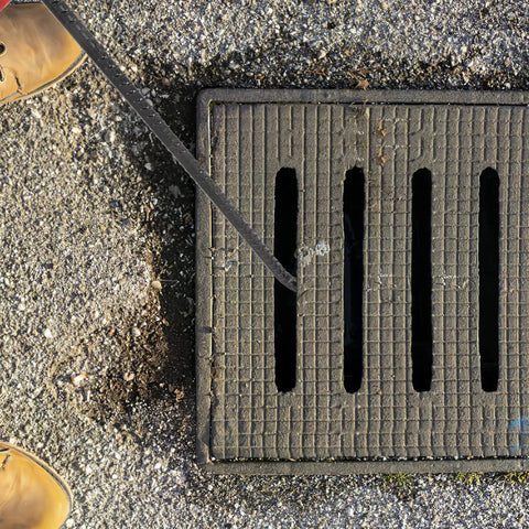 Heavy Duty Steel Manhole Cover Opener With Solid T Handle Grip Rust Resistant Multi Purpose Pull Lifter Hook For Sewer Lid Snagging And Jobsite Hauls No Sweat Tradesman Gear near a sewer grate.