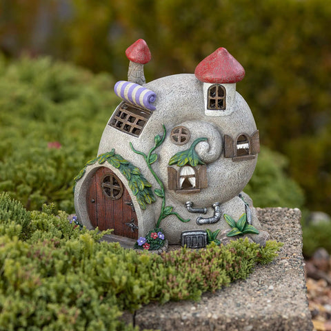 Snail Shell Fairy Cottage Solar Powered LED Light for Outdoor Decor, whimsical garden ornament on mossy stone path.