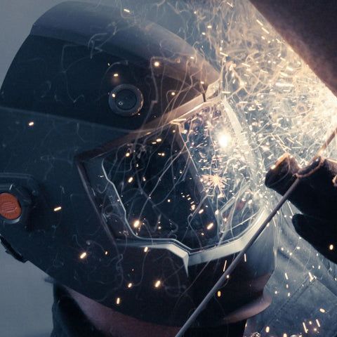 Welder using Panoramic Welding Helmet With True Color Auto Darkening Filter Three Window Design Built In Cooling Fan And LED Headlamp ANSI Z87.1 Plus Certified Ideal For Pros And DIYers