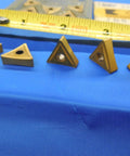 10 Piece New TiN Coated Carbide Turning Inserts TNMP 332 KC810 16 04 08 Pack For CNC Lathe And Milling Machines High Precision Wear Resistant Premium Grade For Tough Materials And Long Tool Life, triangular inserts on blue surface