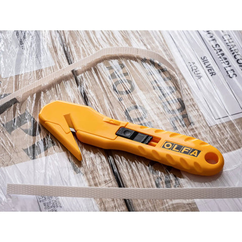 Concealed Blade Safety Knife With Protected Blade For Tape Slitting And Packaging Tasks 4mm Throat Delivers Continual Safe Blade Exposure And Easy One Hand Use For Shipping Warehousing And DIY Jobs. yellow concealed blade safety knife on taped shipping boxes