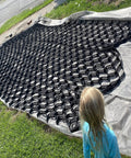 Child looking at uninstalled Hardcore Gravel Stabilizer Grid For Patios, Driveways And Slopes on a lawn.