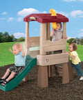 Children playing on Play Naturally Lookout Treehouse Outdoor Playset For Backyard Fun With Slide And Climber in a grassy area