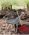 Wheelbarrow filled with manure next to red rake with Six Piece Set Of Manure Fork Replacement Heads Red With 18 Tines Screws And Nuts