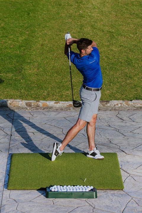 Man practicing golf with Commercial Quality Golf Ball Tray For Practice Mats High Impact Plastic Flange Sits Under Mat green tray