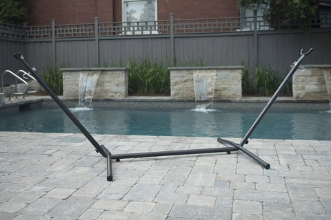Universal Space Saving Steel Hammock Stand 9 Foot Charcoal Color, Tool Free Assembly by a pool with adjustable hooks.