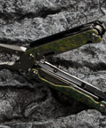 Ultra Lightweight Titanium Alloy Multitool Pliers with Camouflage Finish, 420 Stainless Steel Plier Head open on rocky surface