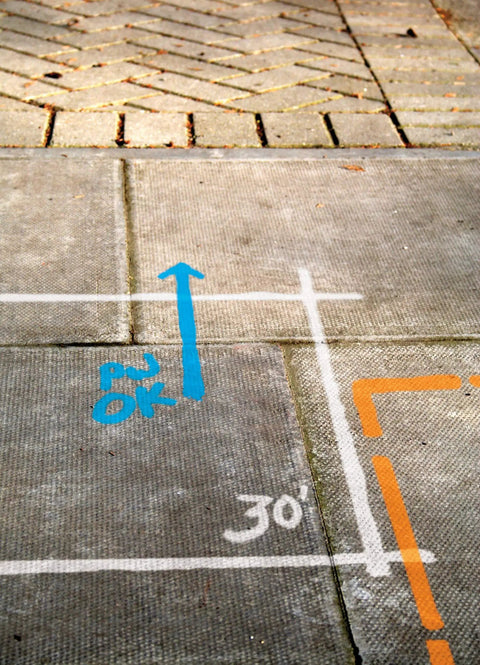 Industrial Choice M1400 Water Based Construction Marking Spray Paint marking concrete pavement with colorful lines.