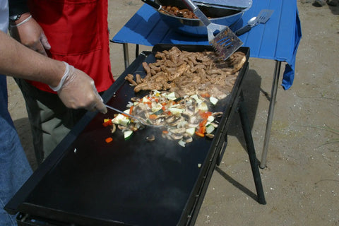 Professional Fry Griddle for Large Cookouts 3 Burner Steel Griddle with vegetables and meat cooking outdoors