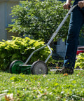 Man using No Sweat 14 Inch 5 Blade Push Reel Lawn Mower With Ball Bearing Reel And Cushioned T Style Handle Adjustable Cutting Height