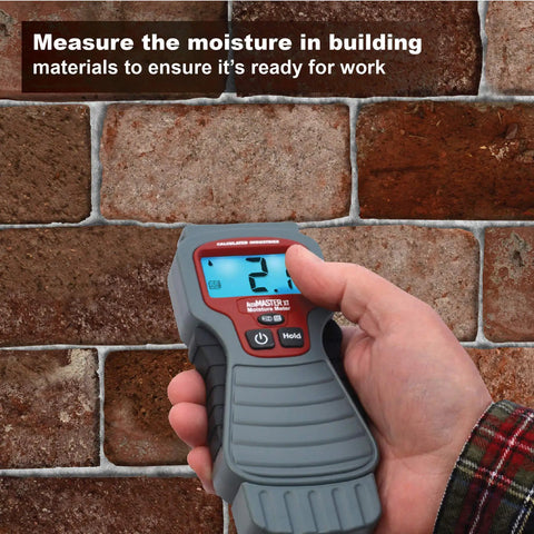 Hand using 7440 AccuMASTER XT Digital Moisture Meter Handheld Pin Type With Backlit LCD Display on brick wall