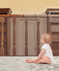 Toddler in front of Two Pack Brown Baby Banister Guard Net For Stairs And Balconies, Kid And Pet Safe Stair Netting installed.