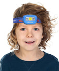 Child wearing hands free headlamp with adjustable lighting modes, 165 lumen, battery powered, waterproof and impact resistant