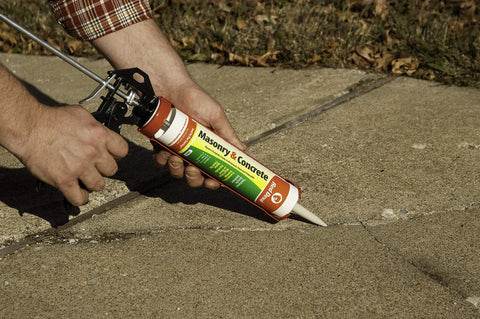 Man applying Concrete Look Acrylic Sealant For Masonry And Concrete Surfaces Seals Cracks And Joints On Brick Block Stone